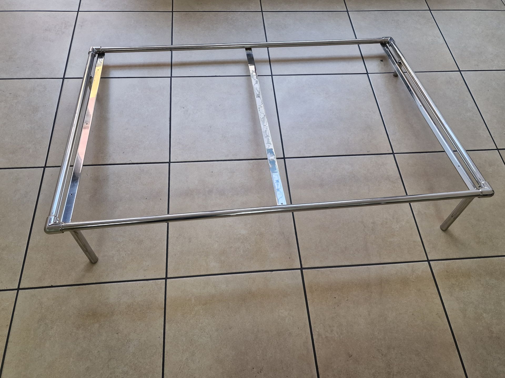 Μεταλλικός σκελετός με πόδια, που στηρίζεται σε πλακόστρωτο δάπεδο.