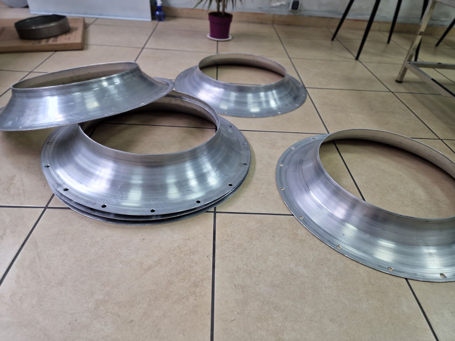 Αρκετοί ασημένιοι μεταλλικοί δακτύλιοι με φαρδιές άκρες σε πλακάκια δαπέδου.