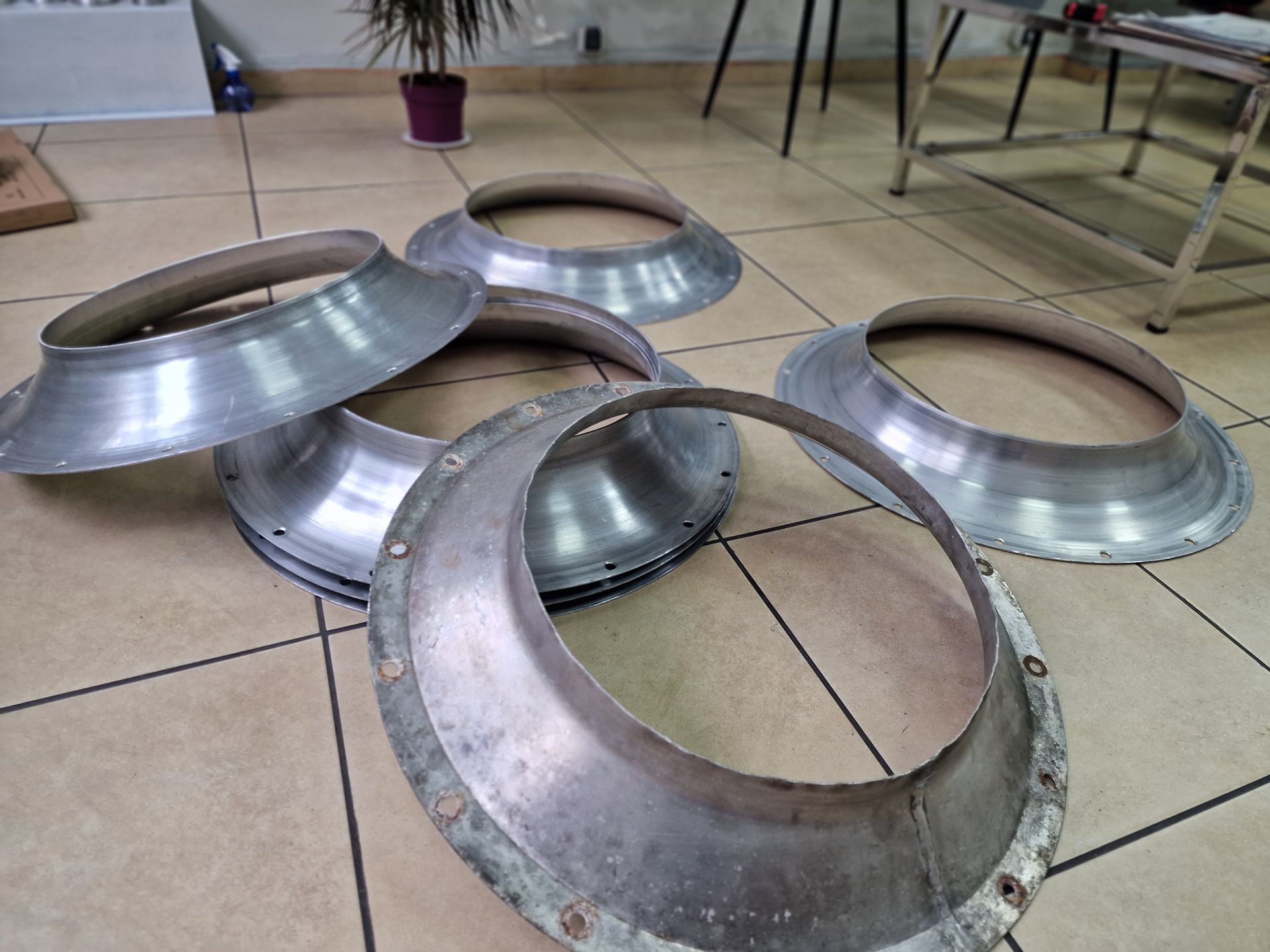 Πέντε μεταλλικοί, φαρδείς δακτύλιοι σε πλακάκι δαπέδου. Οι δακτύλιοι διαφέρουν ελαφρώς στην εμφάνιση.