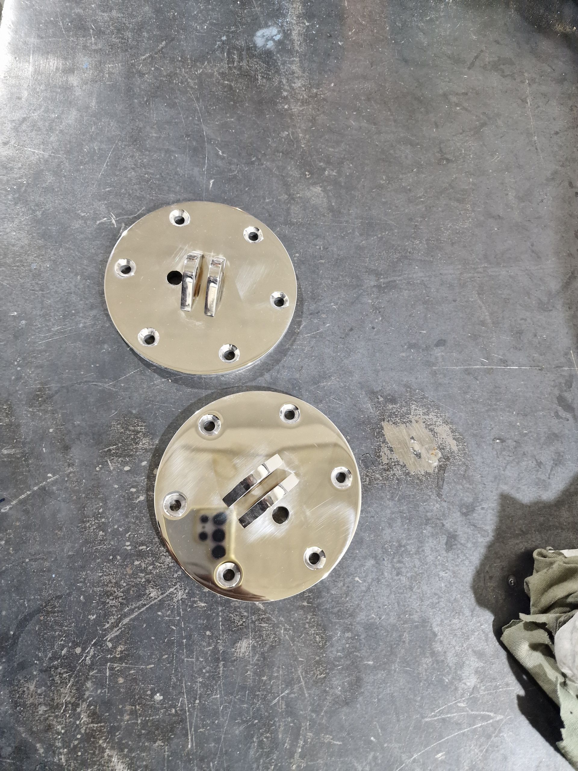 Δύο κυκλικές μεταλλικές πλάκες με πολλαπλές οπές και μια κεντρική μεταλλική βάση.