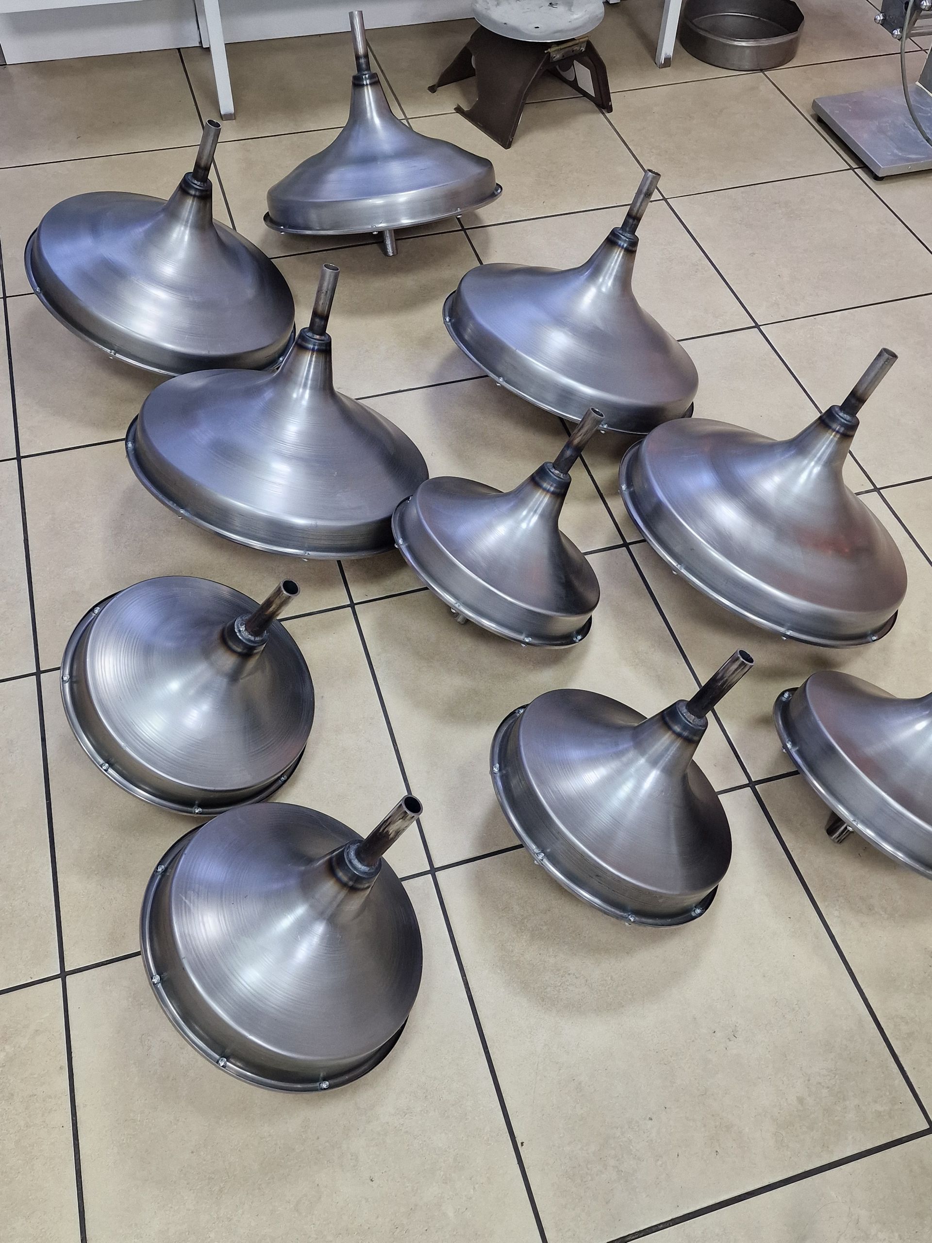 Δέκα μεταλλικά χωνιά σε πλακόστρωτο δάπεδο, διαφόρων μεγεθών και στραμμένα προς τα πάνω.