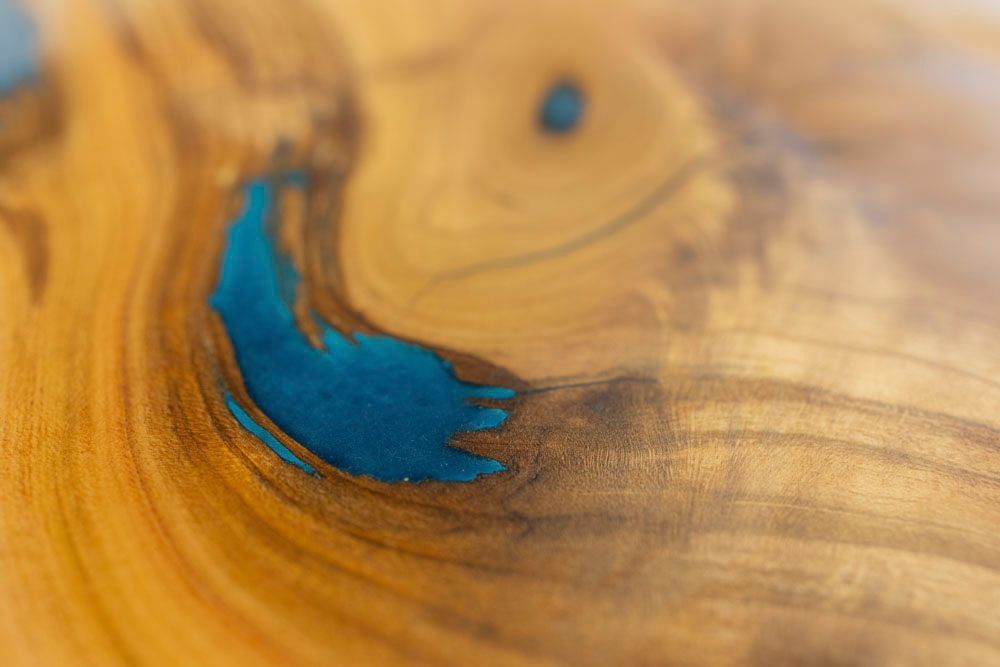 Eine Person hält ein Stück Holz und Harz in der Hand.