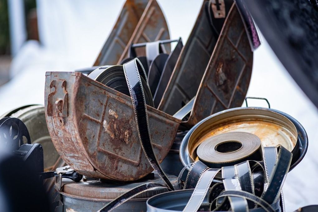 Una pila de contenedores de metal oxidados colocados uno encima del otro.