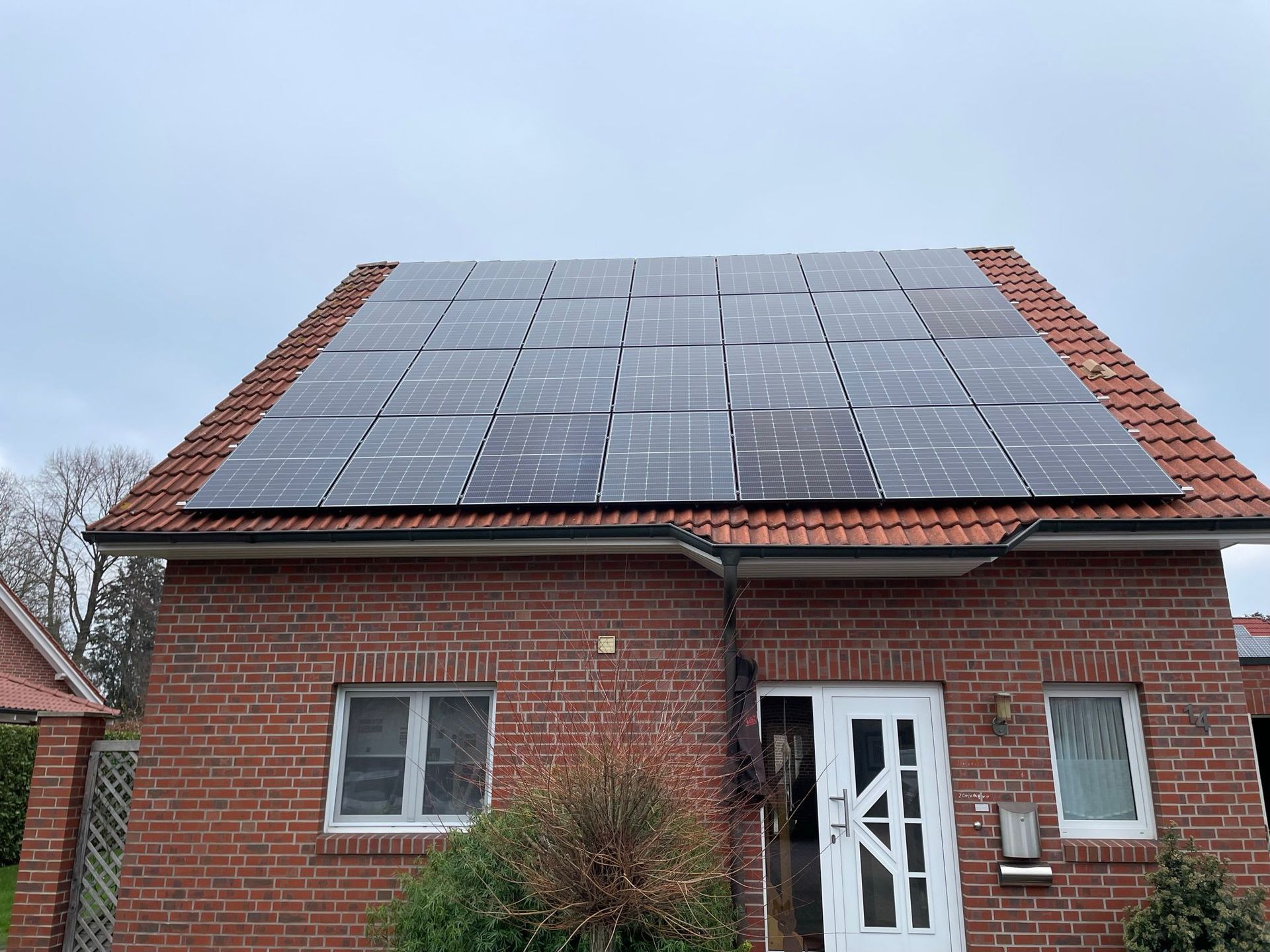 Ein Backsteinhaus mit Sonnenkollektoren auf dem Dach