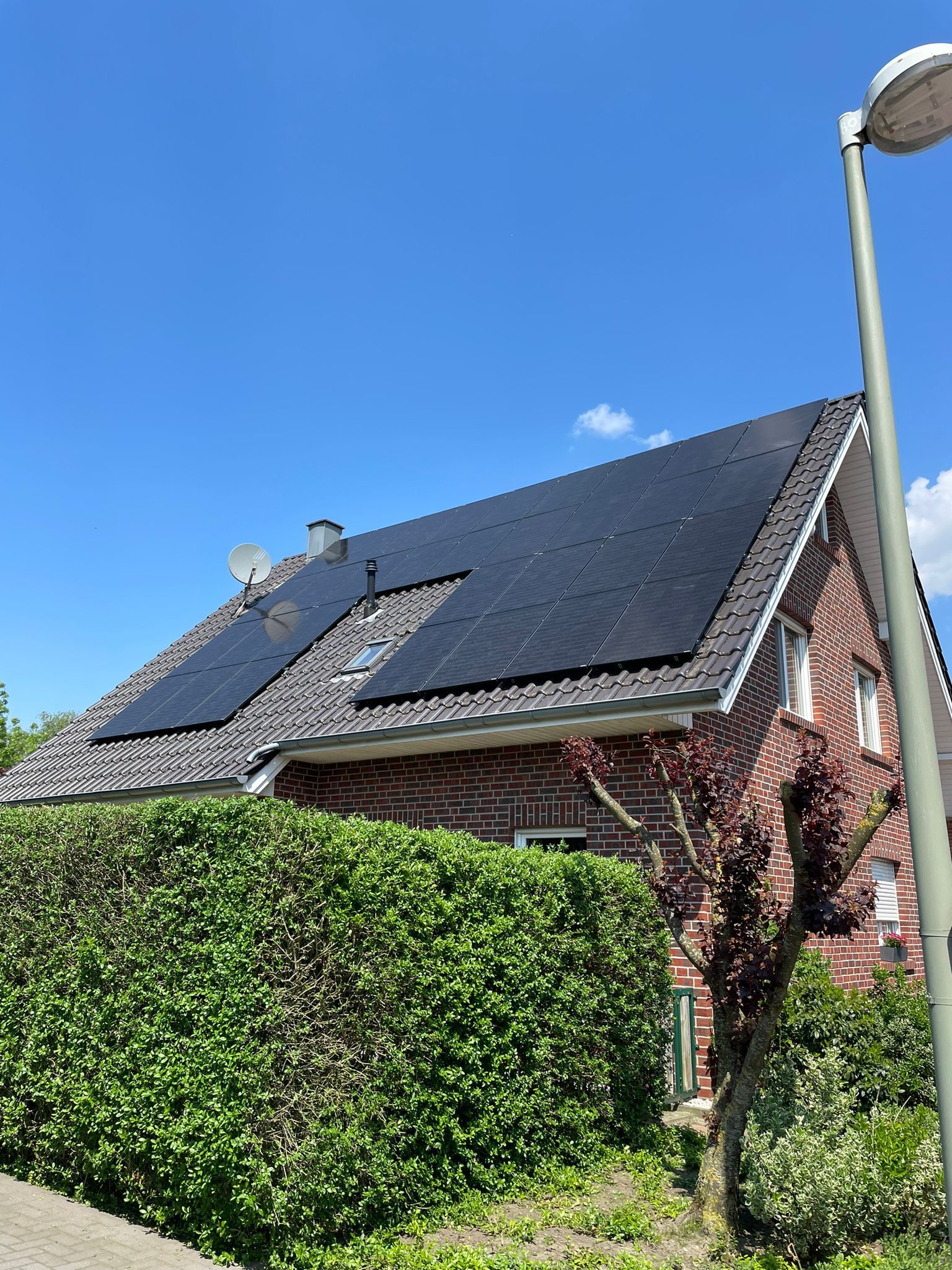 Ein Backsteinhaus mit Sonnenkollektoren auf dem Dach.