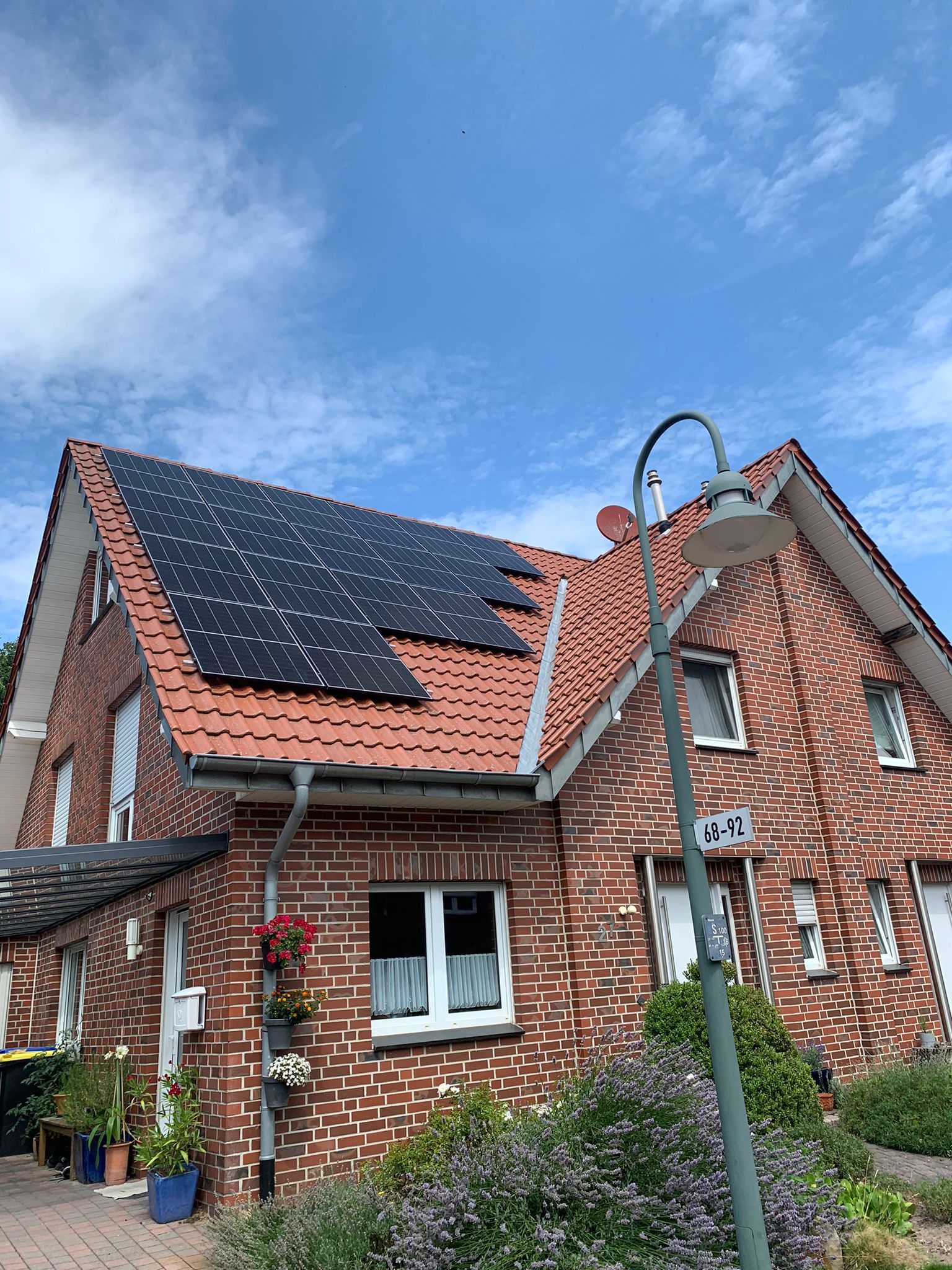 Ein Backsteinhaus mit Sonnenkollektoren auf dem Dach.