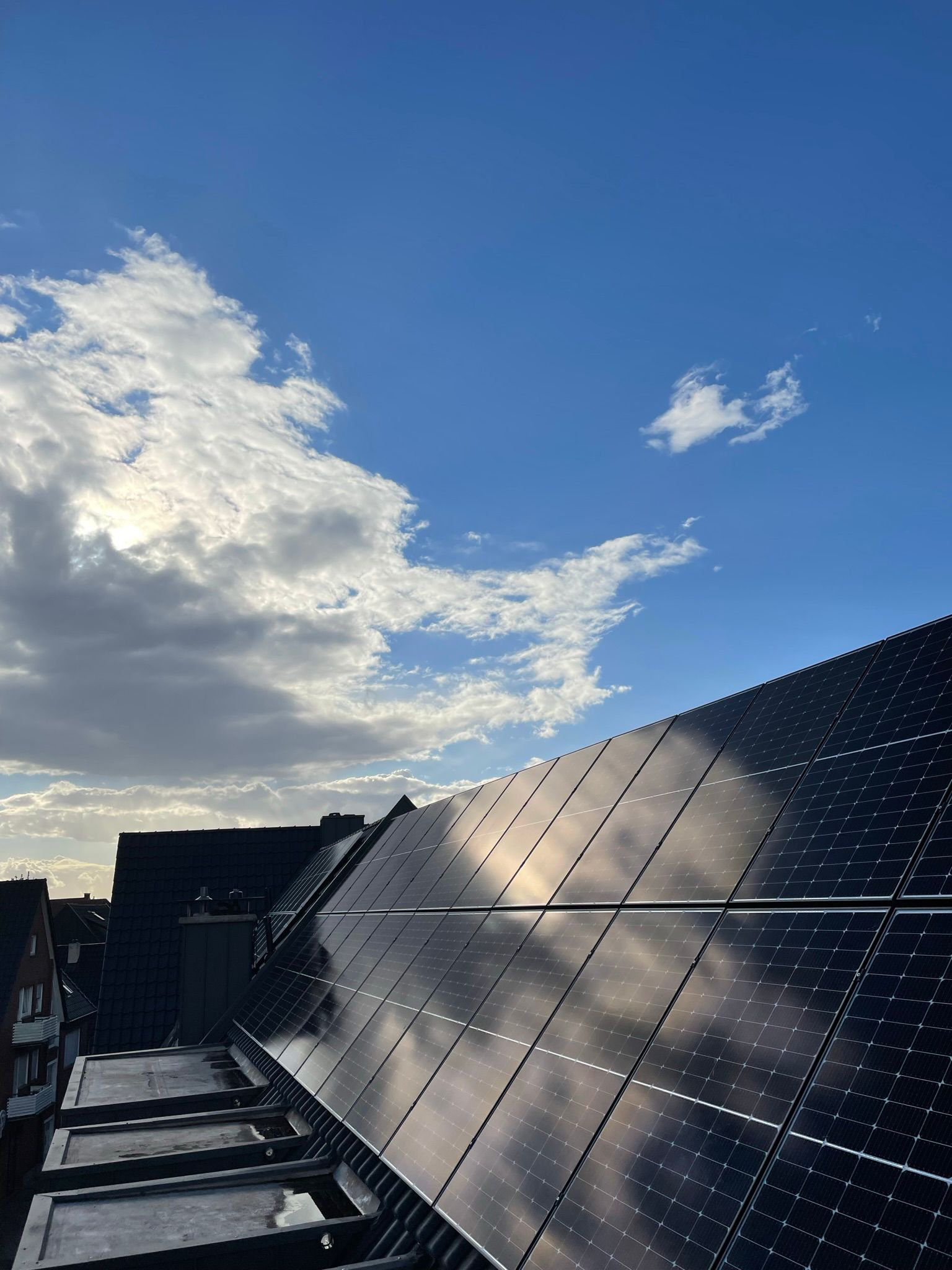 Eine Reihe von Solarmodulen vor einem blauen Himmel mit Wolken