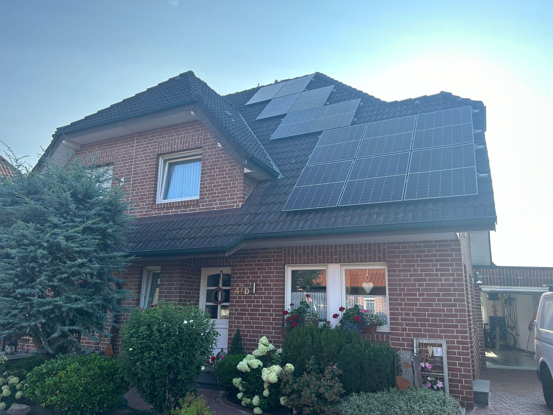 Ein Backsteinhaus mit Sonnenkollektoren auf dem Dach.