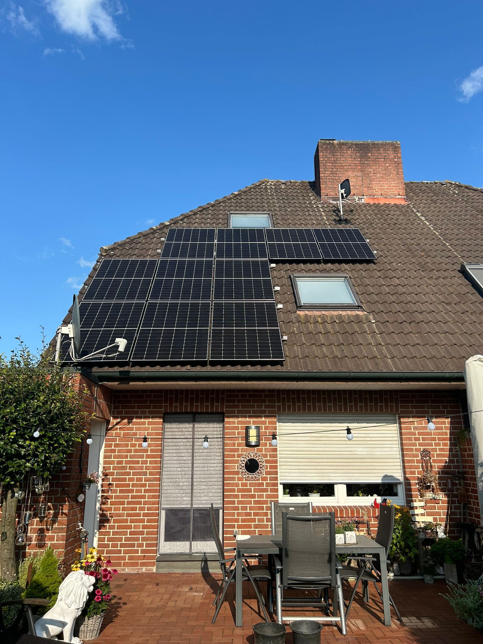 Ein Backsteinhaus mit Sonnenkollektoren auf dem Dach.