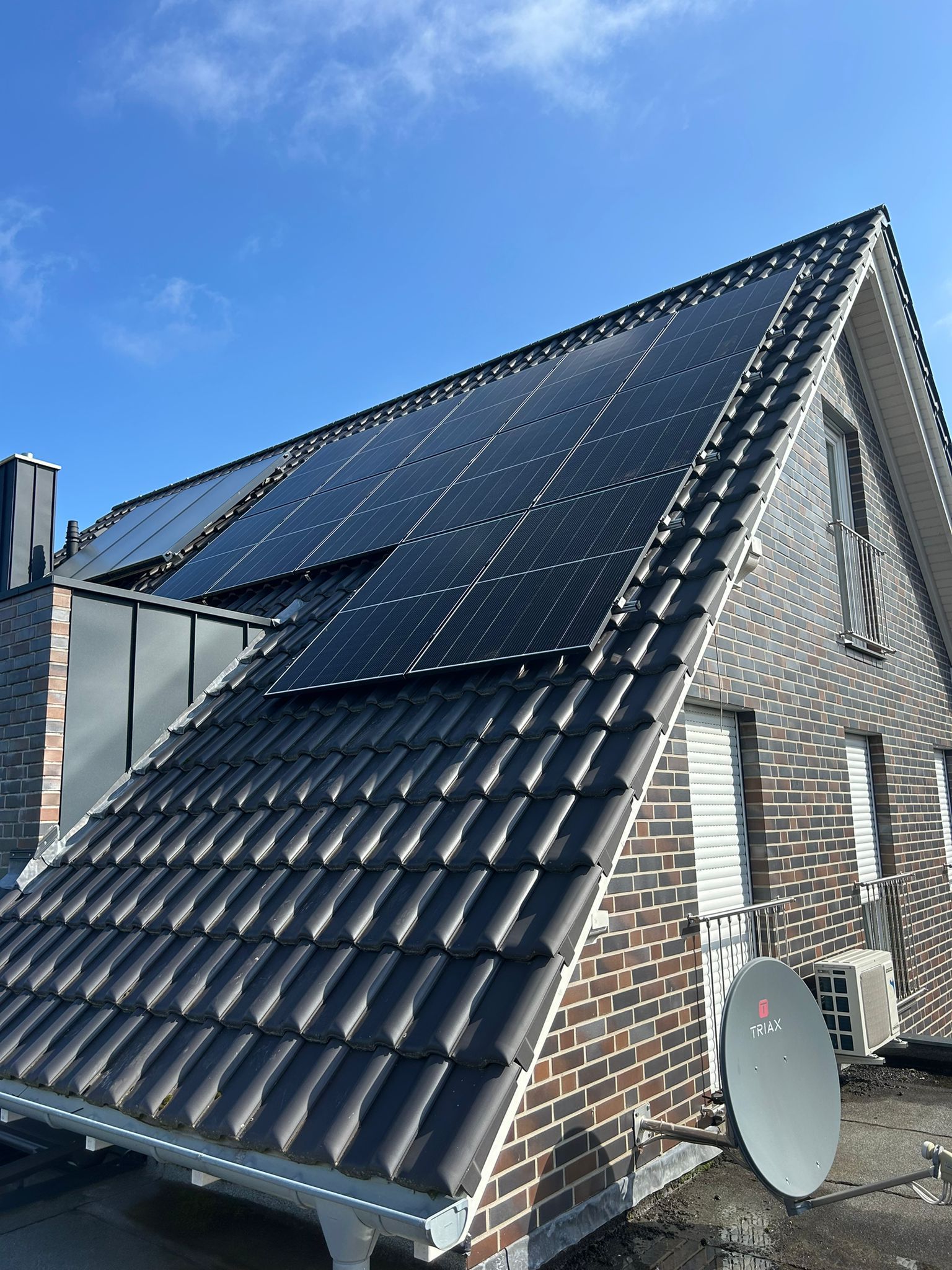 Ein Backsteinhaus mit Sonnenkollektoren auf dem Dach