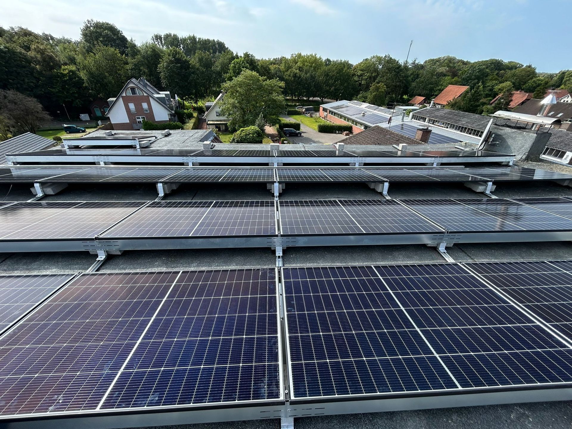 Auf dem Dach eines Gebäudes befinden sich viele Solarmodule.