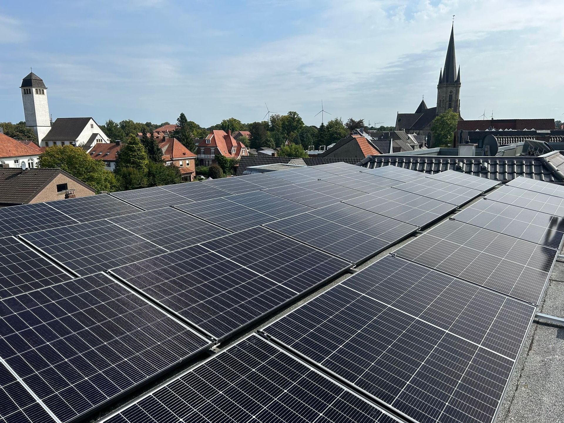 Auf dem Dach eines Gebäudes befinden sich viele Solarmodule.