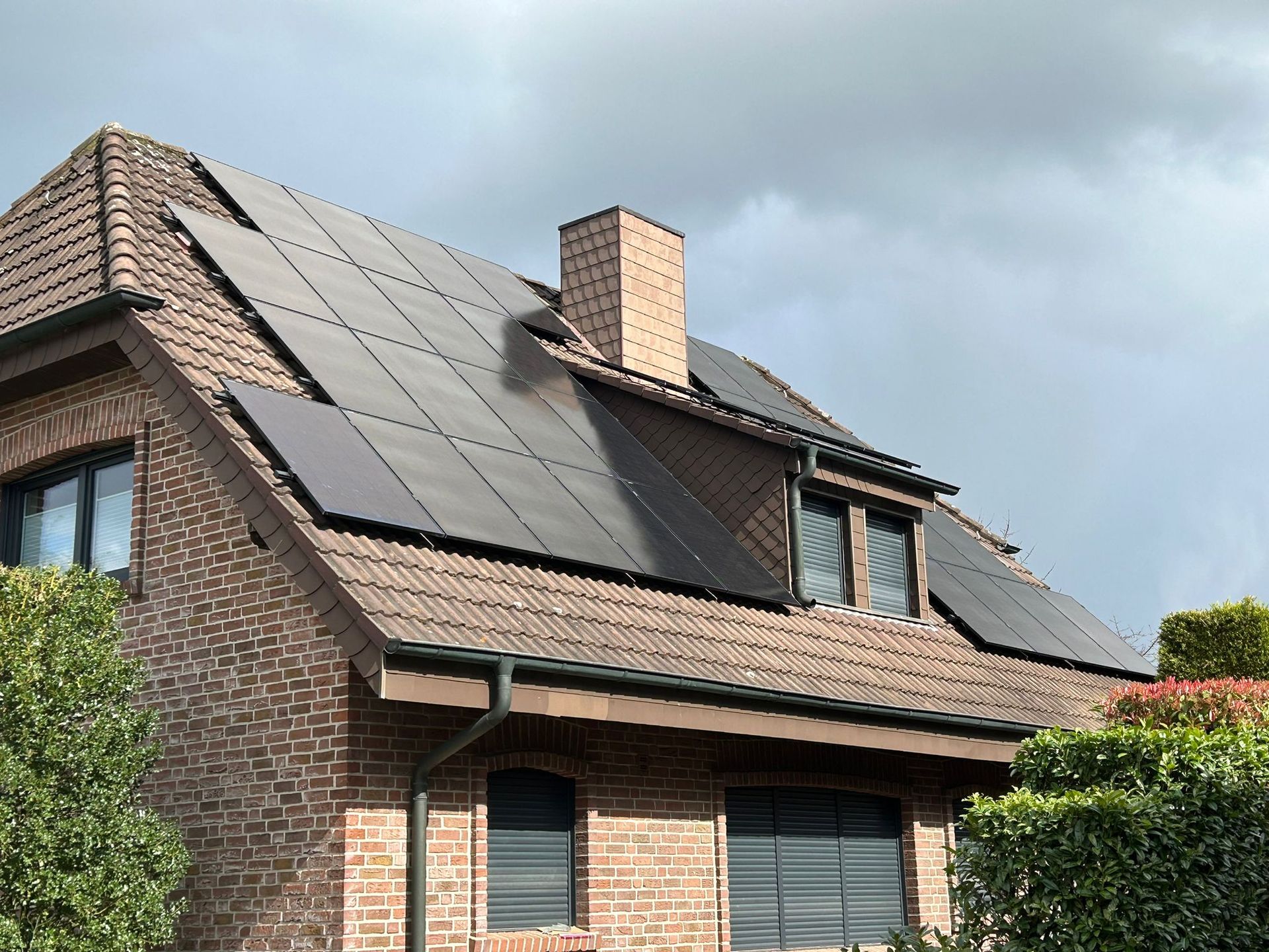 Ein Backsteinhaus mit Sonnenkollektoren auf dem Dach