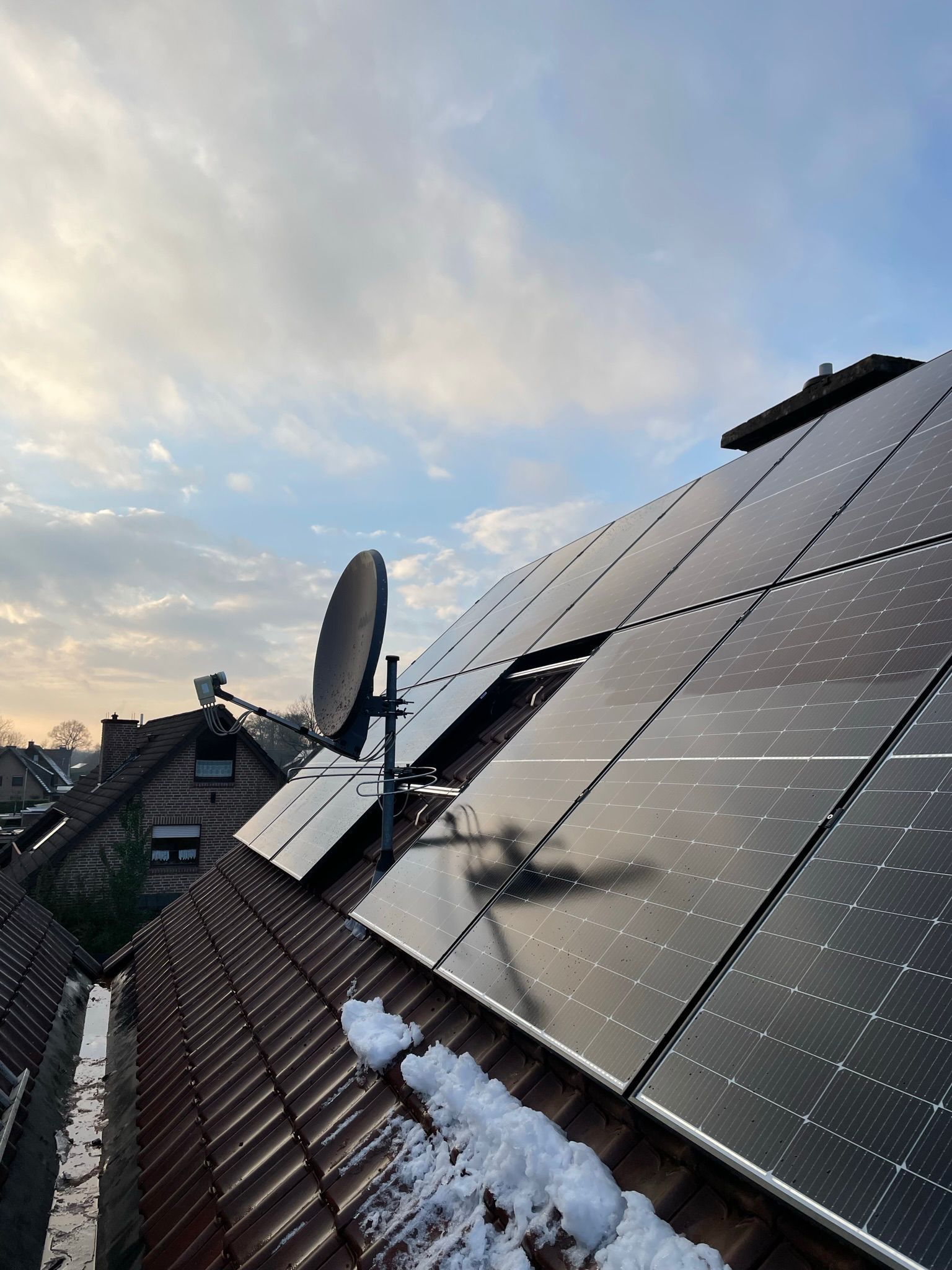 Ein Dach mit Sonnenkollektoren und einer Satellitenschüssel darauf