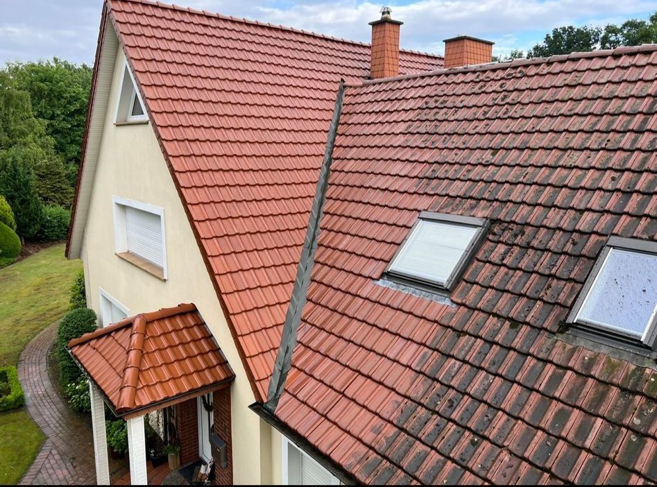 Ein Haus mit einem roten Ziegeldach und zwei Oberlichtern.