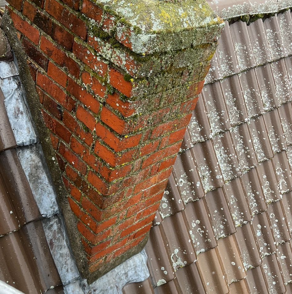 Ein gemauerter Schornstein auf einem Ziegeldach