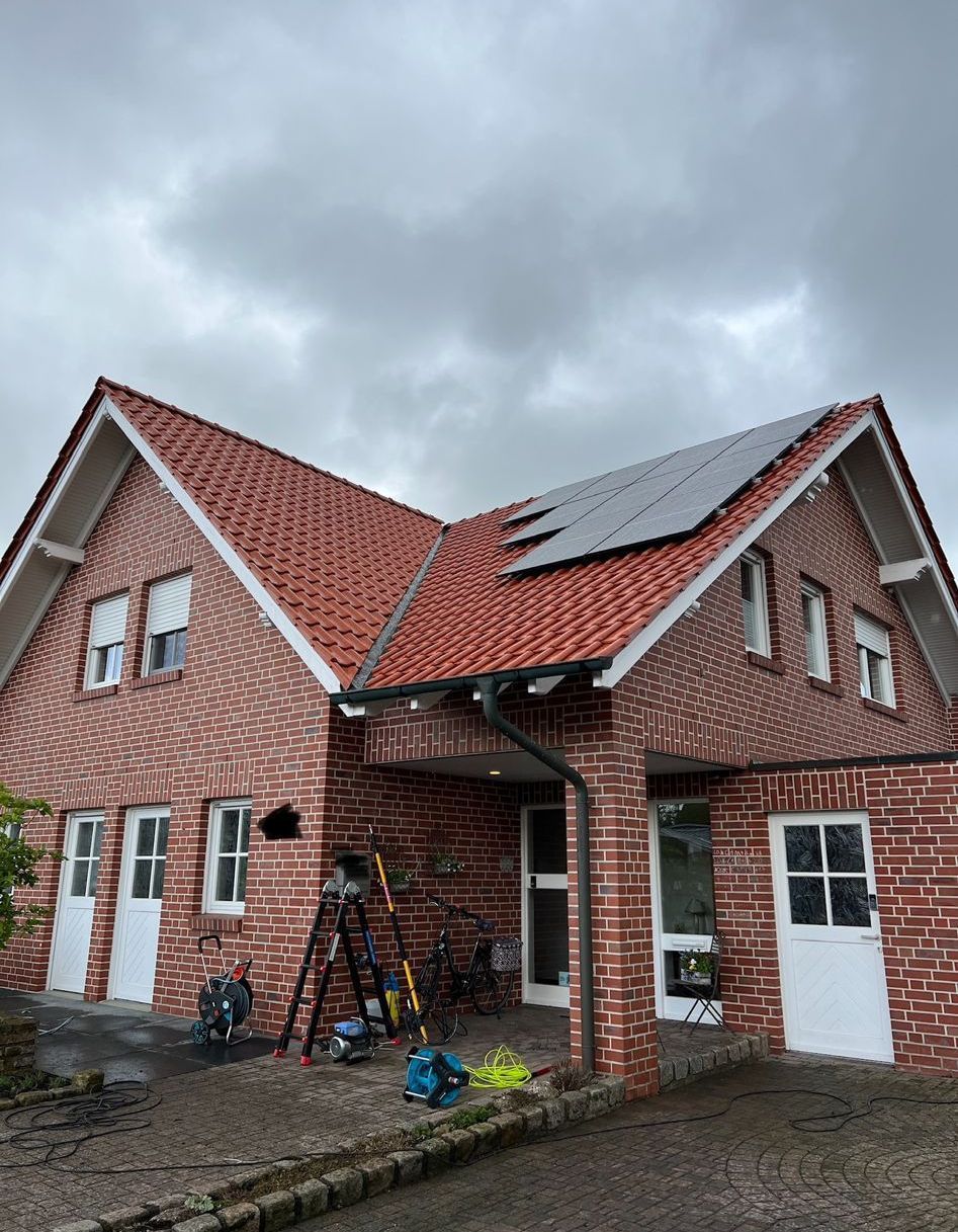 Ein Backsteinhaus mit Sonnenkollektoren auf dem Dach.