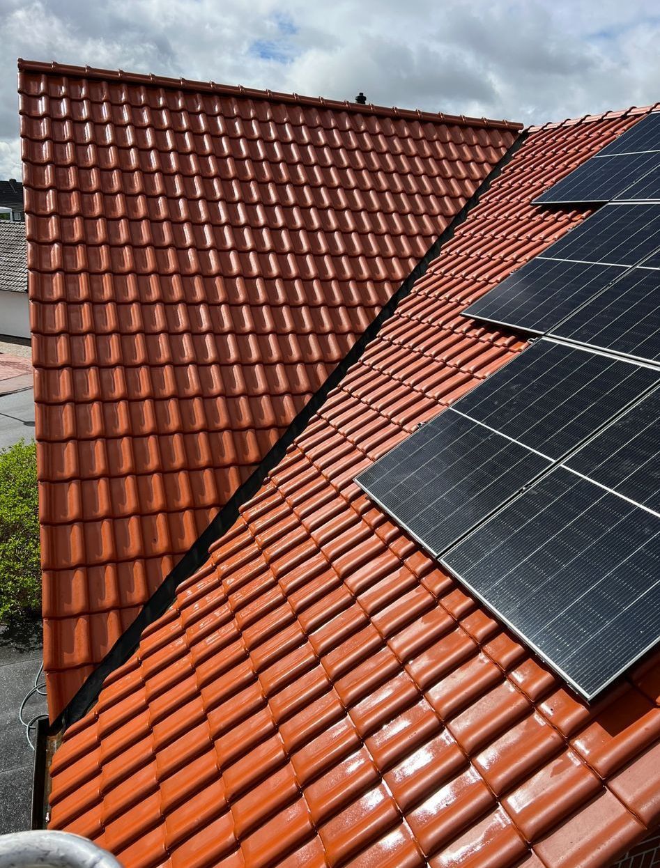Ein Dach mit vielen Ziegeln und Sonnenkollektoren darauf