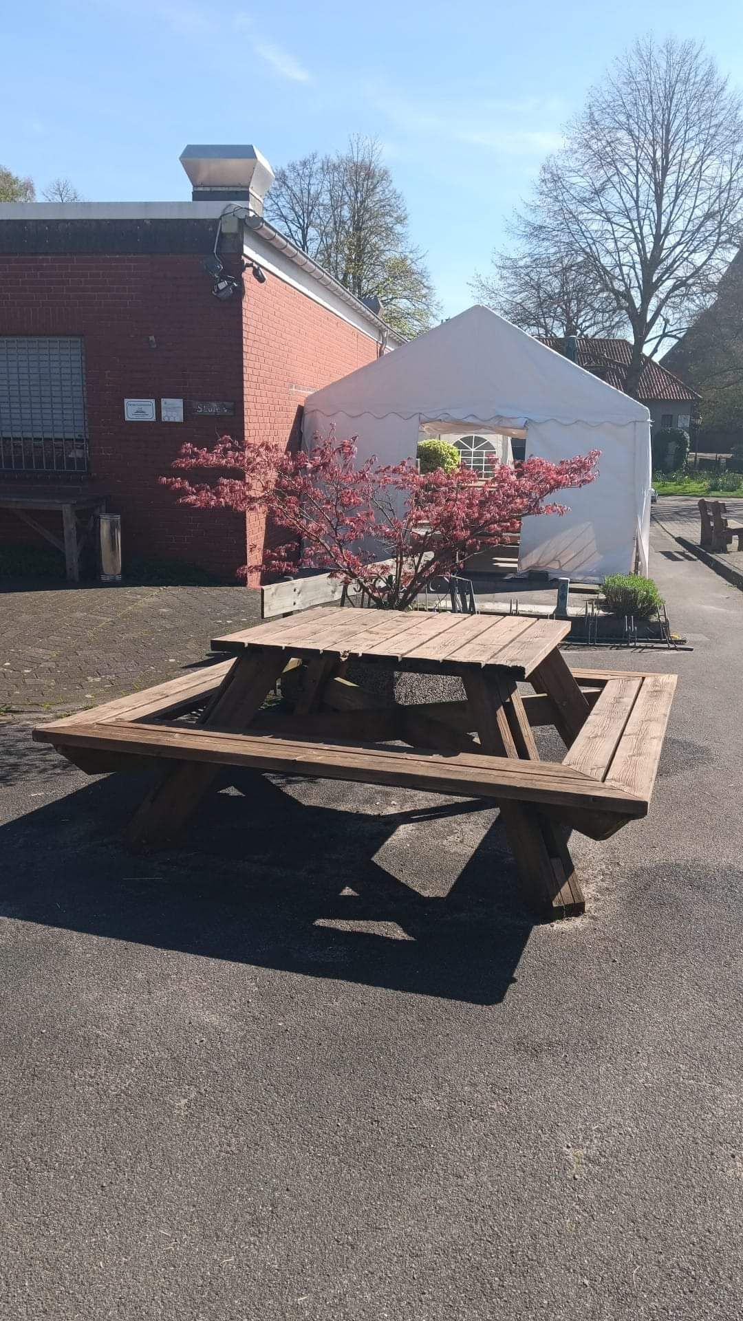 Ein quadratischer Holztisch mit Bank rundum