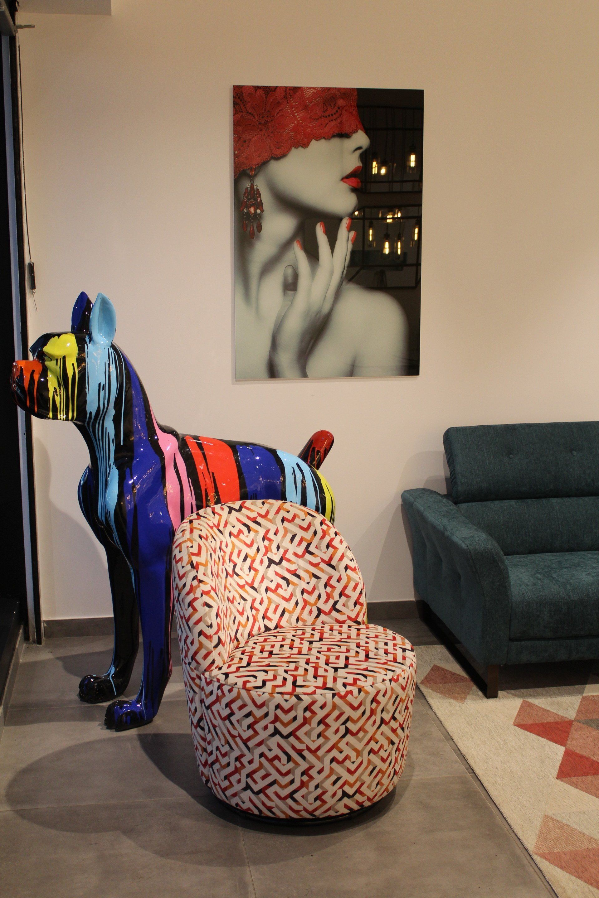 Sculpture de chien noire avec des taches de peinture dessus