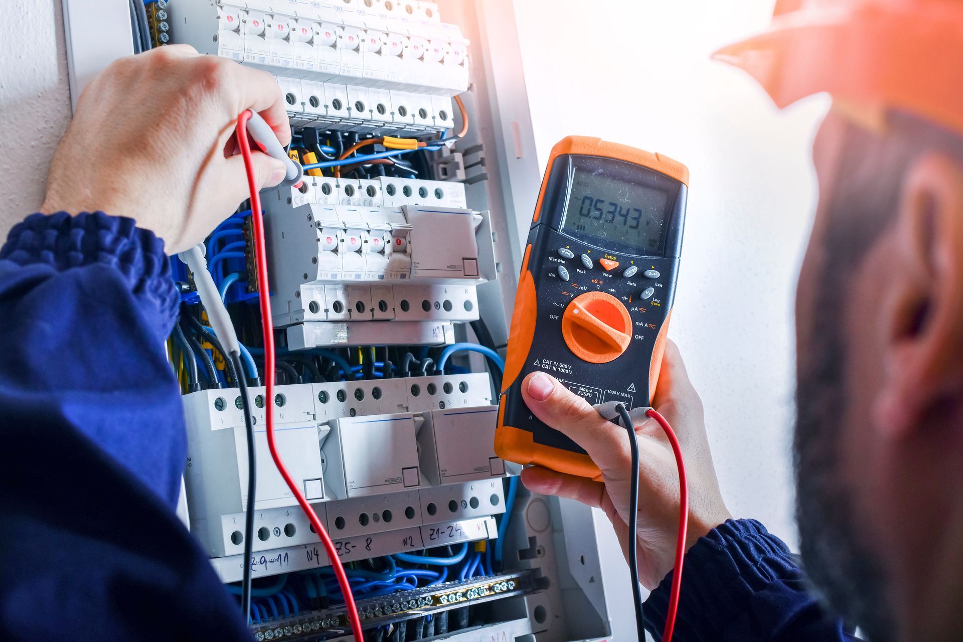 Un électricien règle un tableau électrique