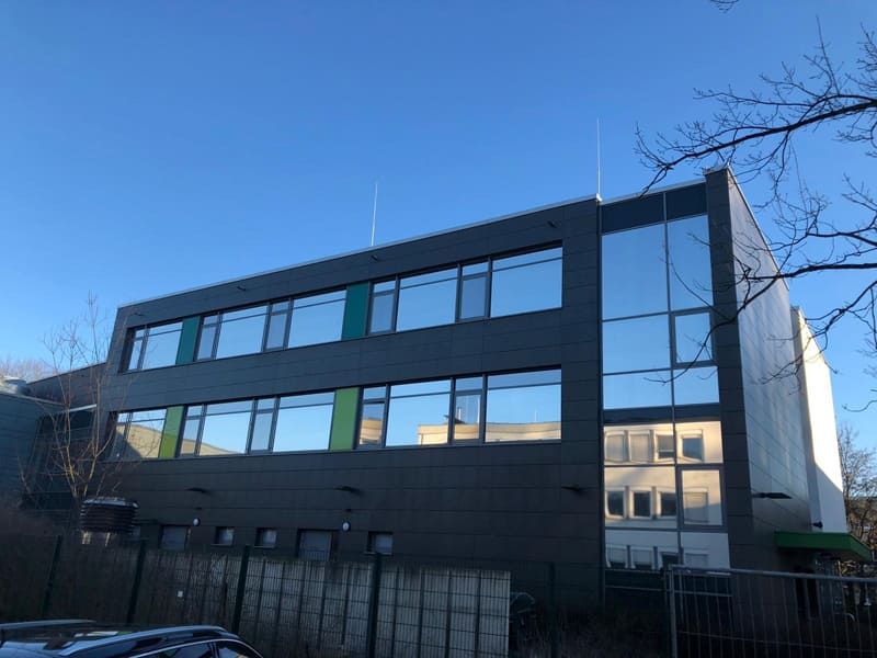 Ein großes Gebäude mit vielen Fenstern und einem blauen Himmel im Hintergrund