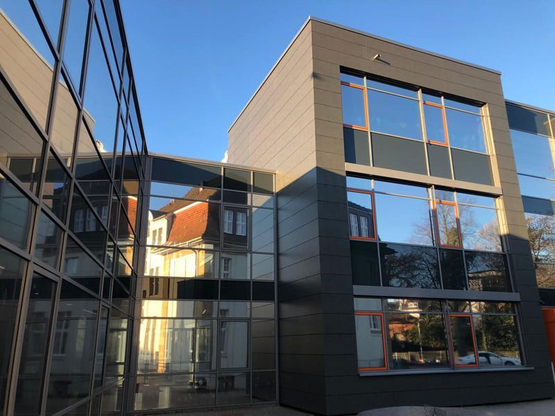 Ein großes Gebäude mit vielen Fenstern und einem blauen Himmel im Hintergrund