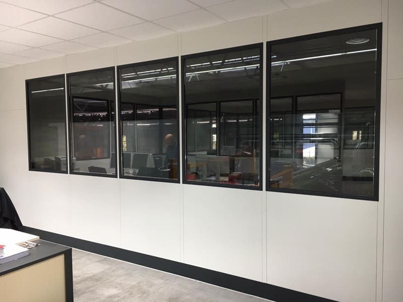 Ein Raum mit vielen Fenstern und einem Schreibtisch.