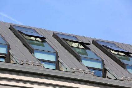 Ein Dach mit vielen Fenstern und einem blauen Himmel im Hintergrund.