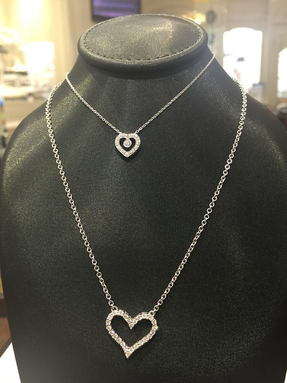 Un collier argenté avec un pendentif en forme de cœur