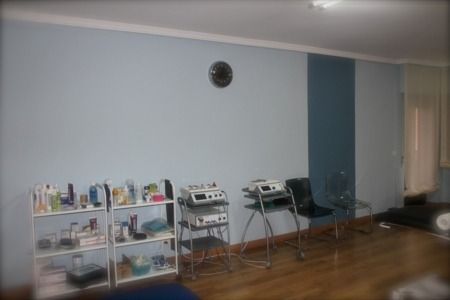 Una habitación con estantes y sillas y un reloj en la pared.