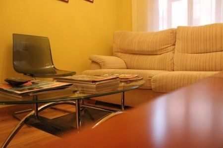 Una sala de estar con un sofá y una mesa de café de cristal.