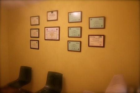 Una habitación con muchos certificados en la pared.
