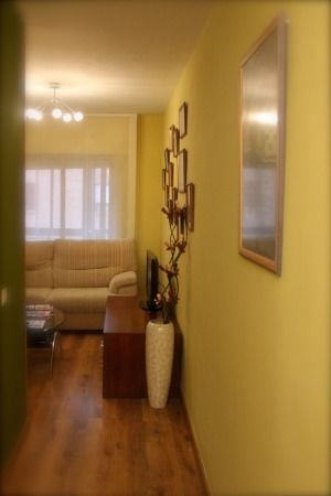 Una sala de estar con paredes amarillas y un sofá.