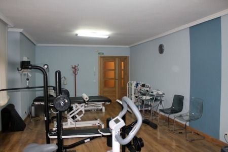 Un gimnasio con una cinta de correr y una bicicleta.