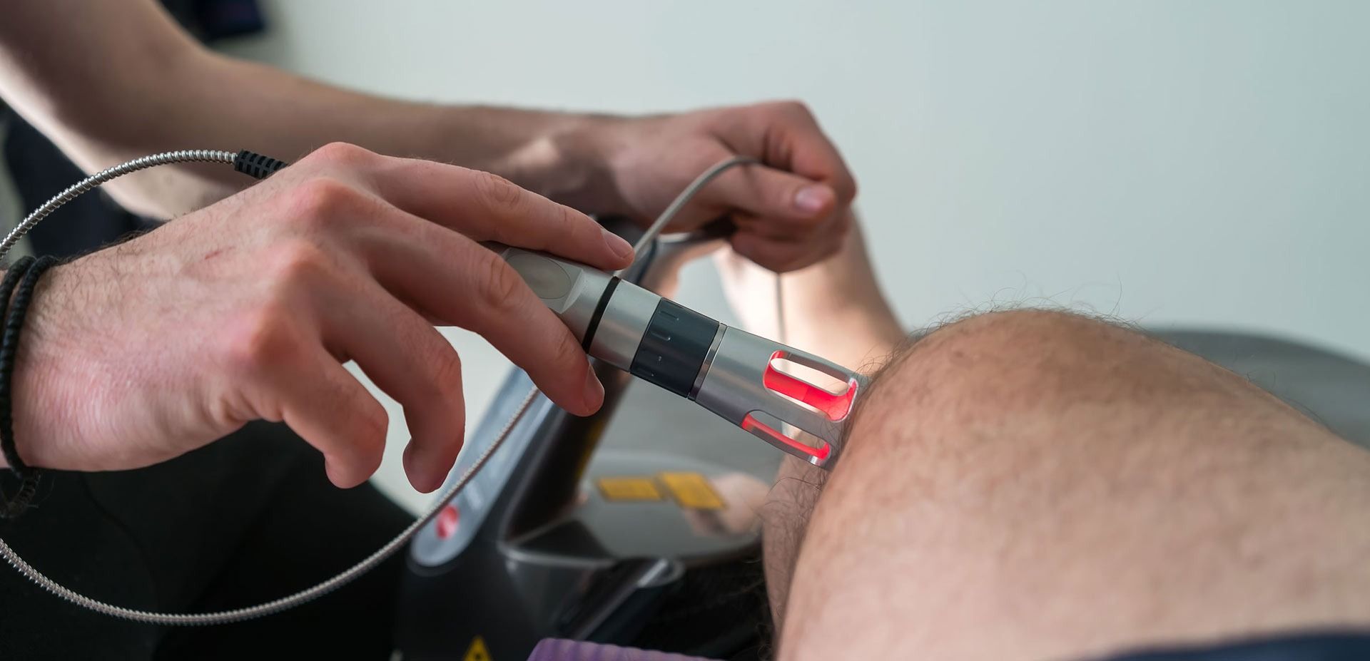Un hombre está recibiendo un tratamiento con láser en su rodilla.