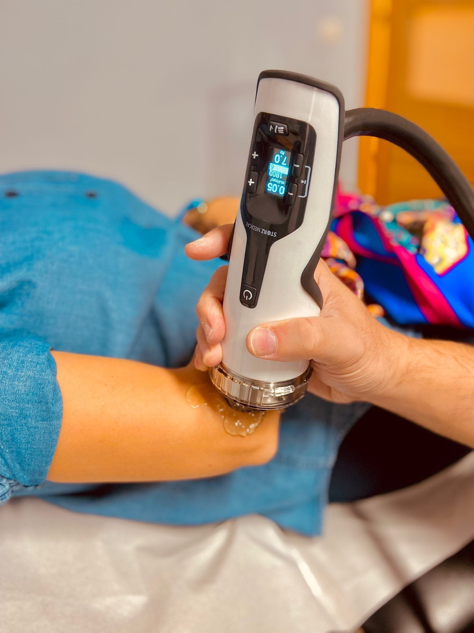 Una persona está usando una máquina en el brazo de otra persona.