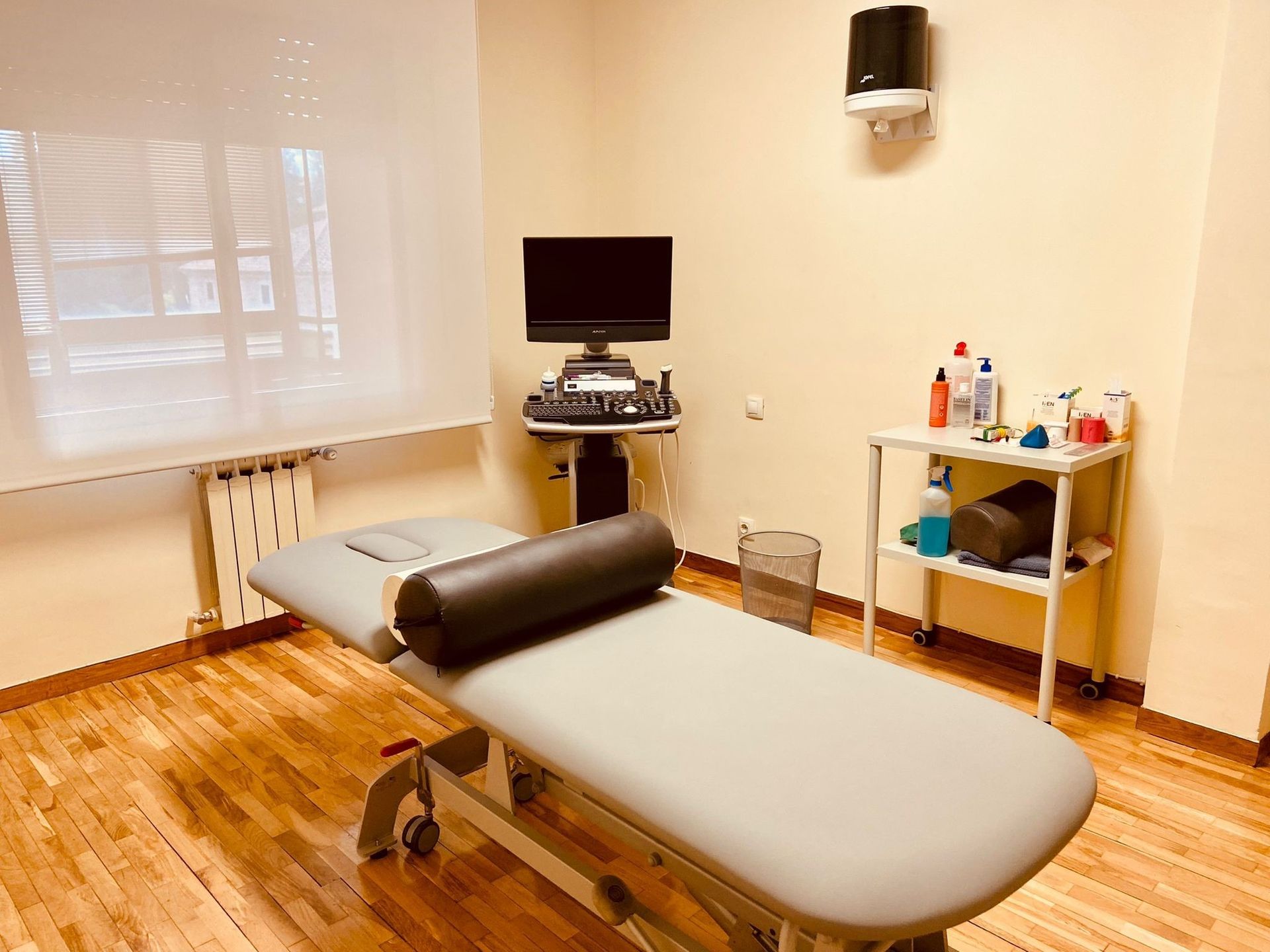 Una habitación con una cama, una computadora y una ventana.