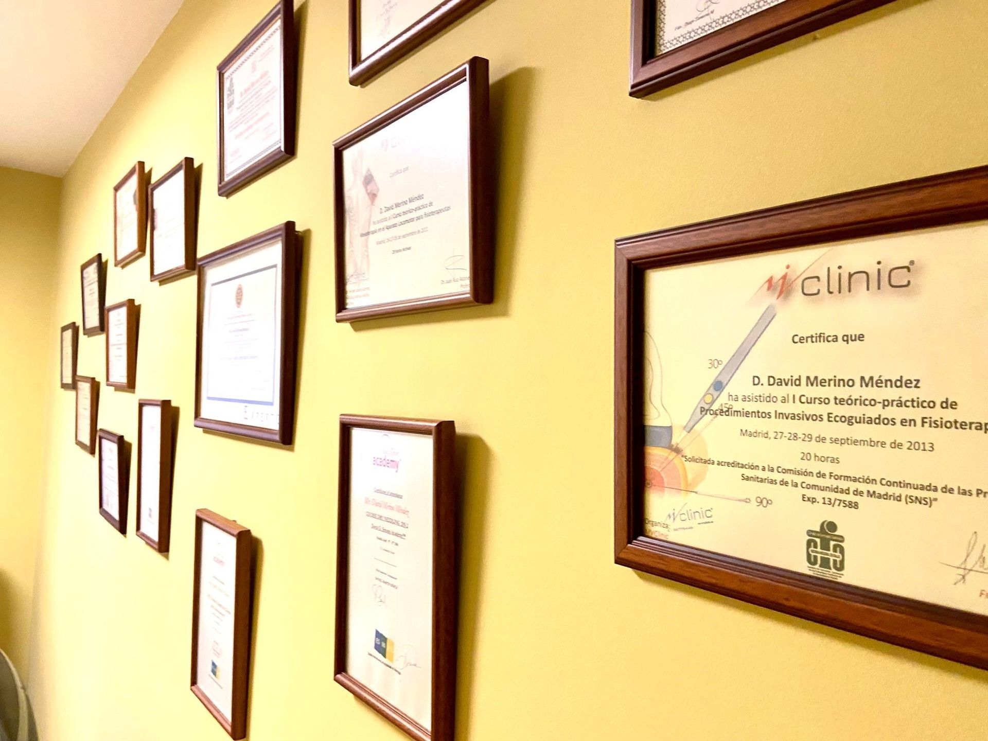 Una pared con muchos certificados colgados.