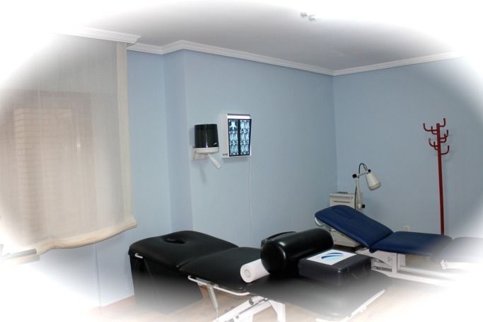 Una habitación con dos camas y una máquina de rayos X en la pared.