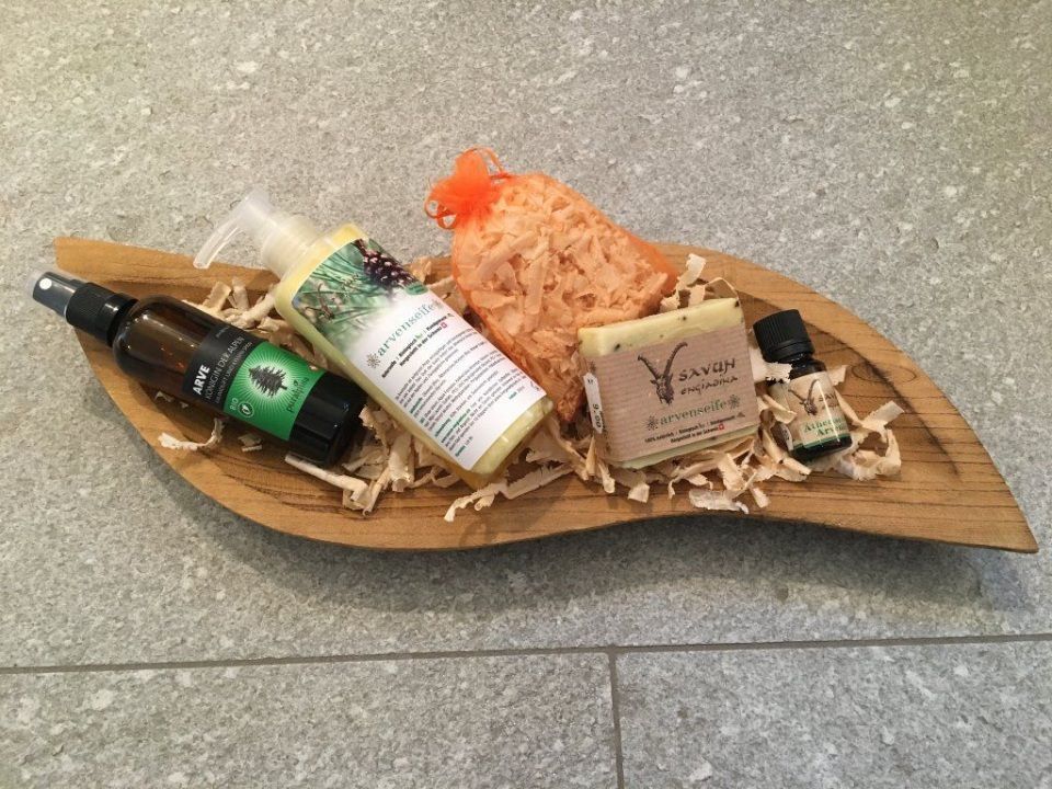 Ein blattförmiges Holztablett mit einer Sprühflasche, Seife und ätherischen Ölen darauf. Foto von Robbi's Schatztruhe