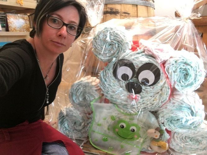 Eine Frau steht neben einem Stapel Windeln in Form eines Teddybären. Foto von Robbi's Schatztruhe