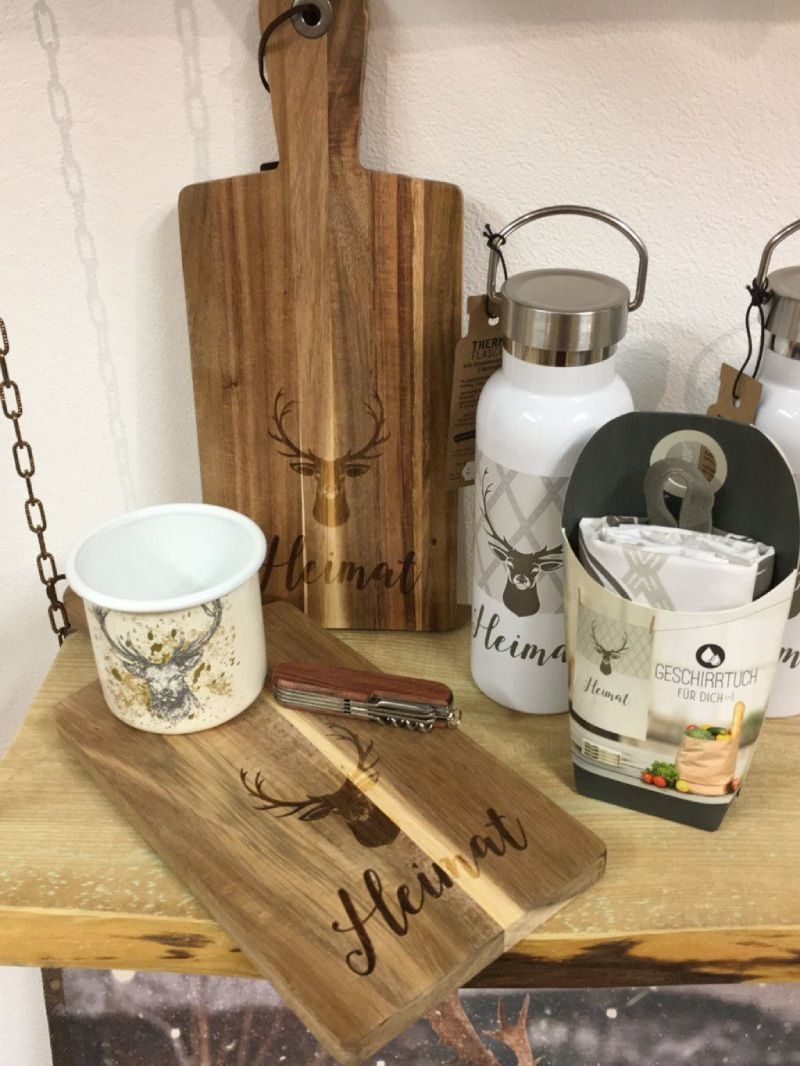 Ein hölzernes Schneidebrett mit dem Wort „Heimat“ darauf und andere Gegenstände. Foto von Robbi's Schatztruhe