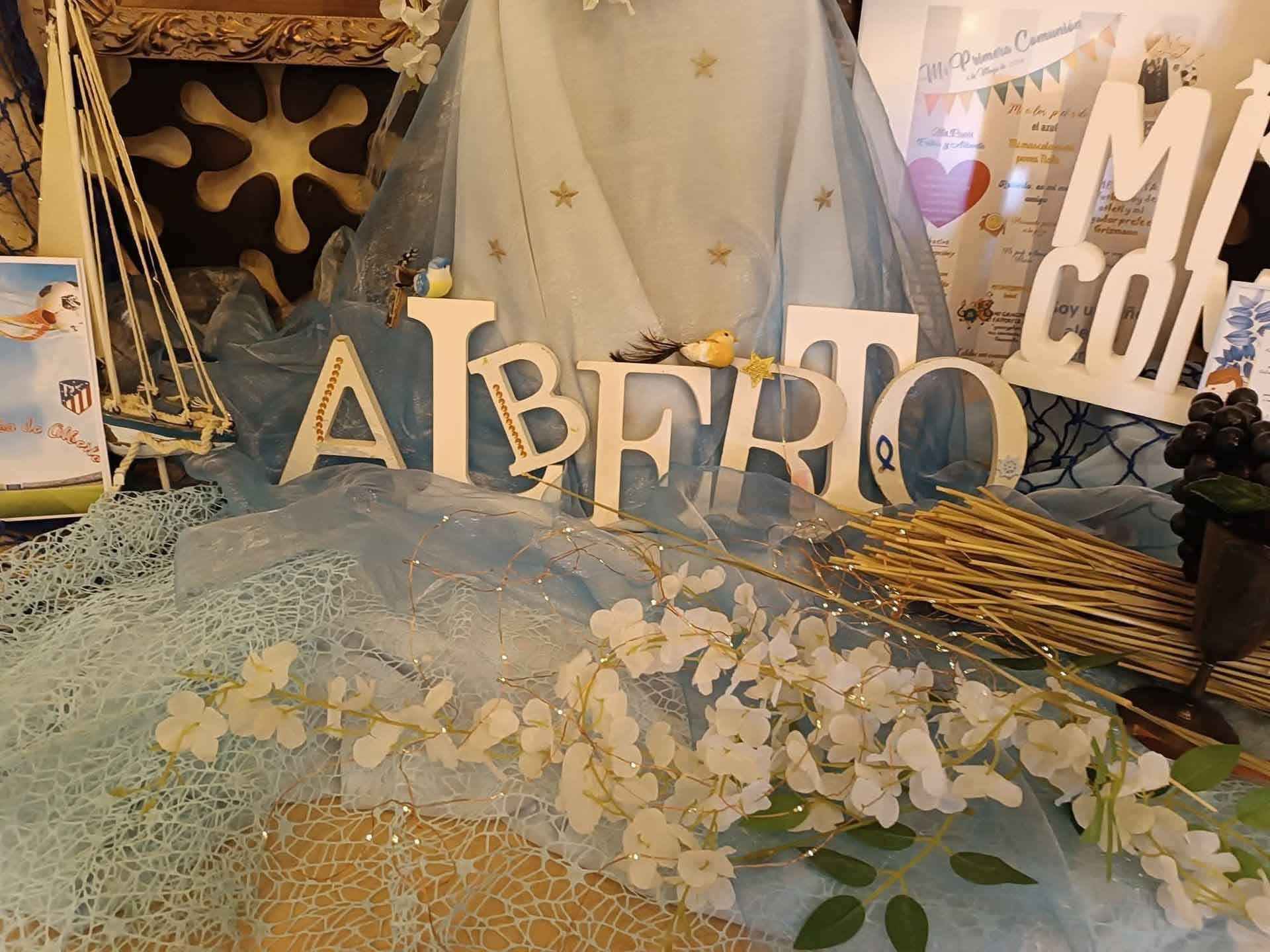 Una mesa con flores y un cartel que dice alberto