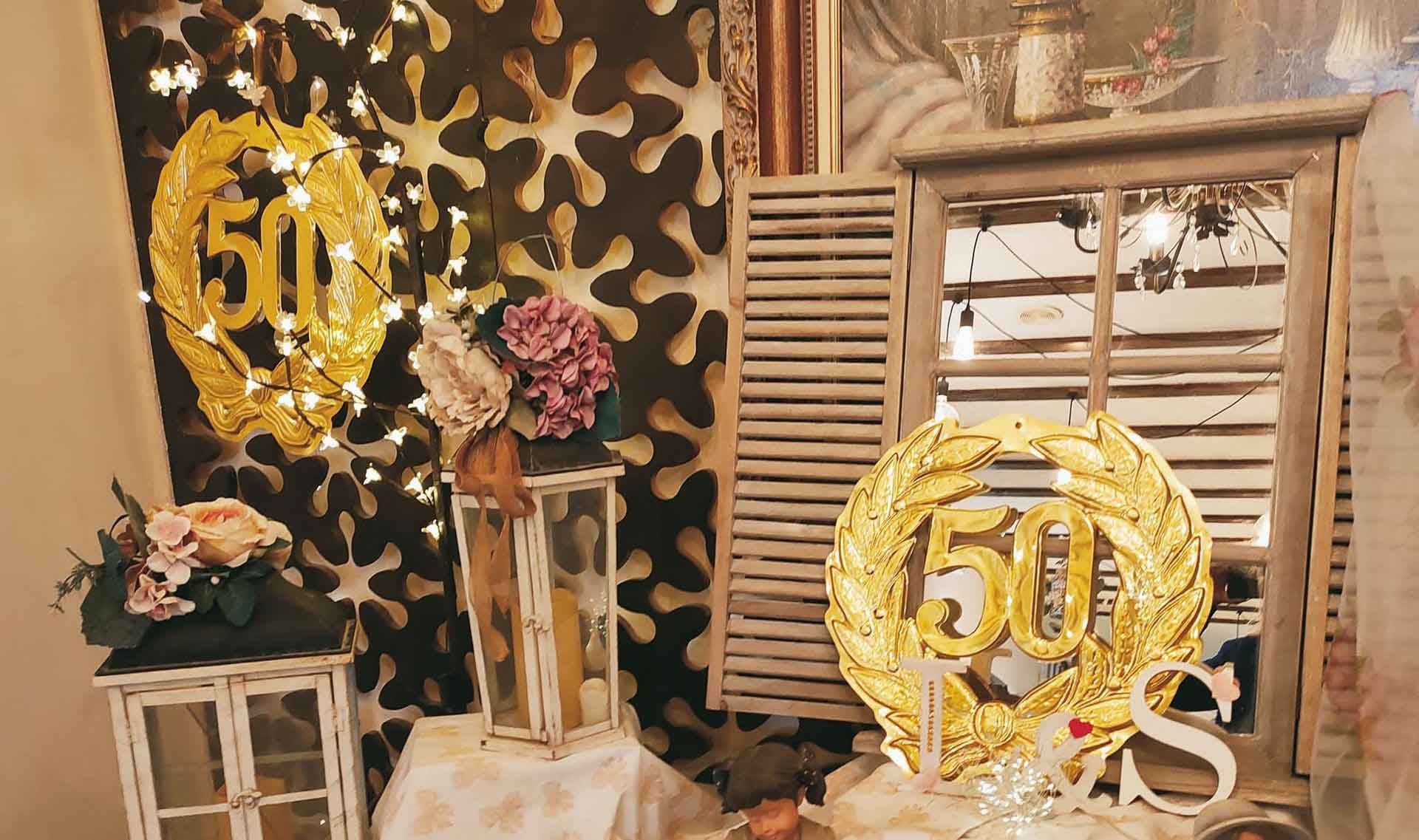 Una habitación decorada para un 50 aniversario con globos y flores.