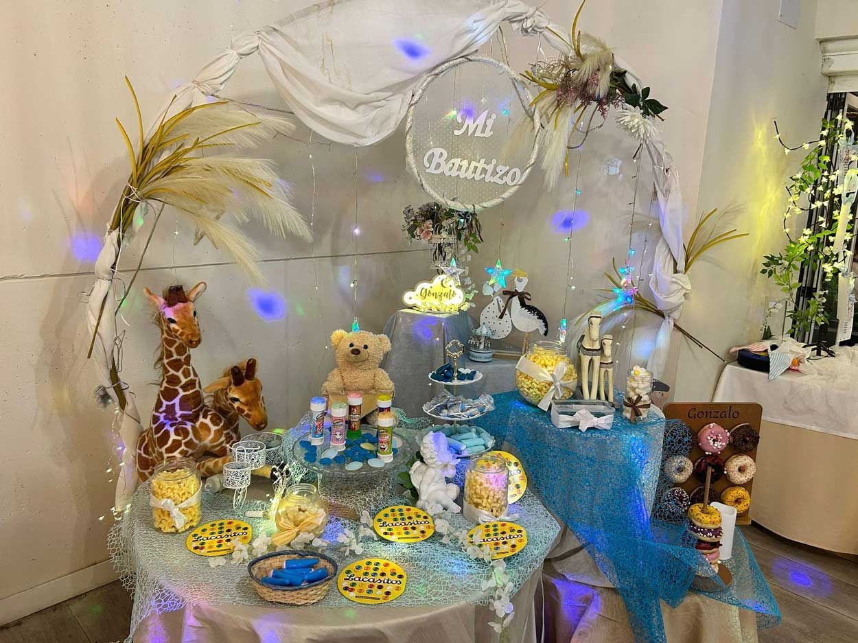 Una mesa decorada para un baby shower con una jirafa y un osito de peluche encima.