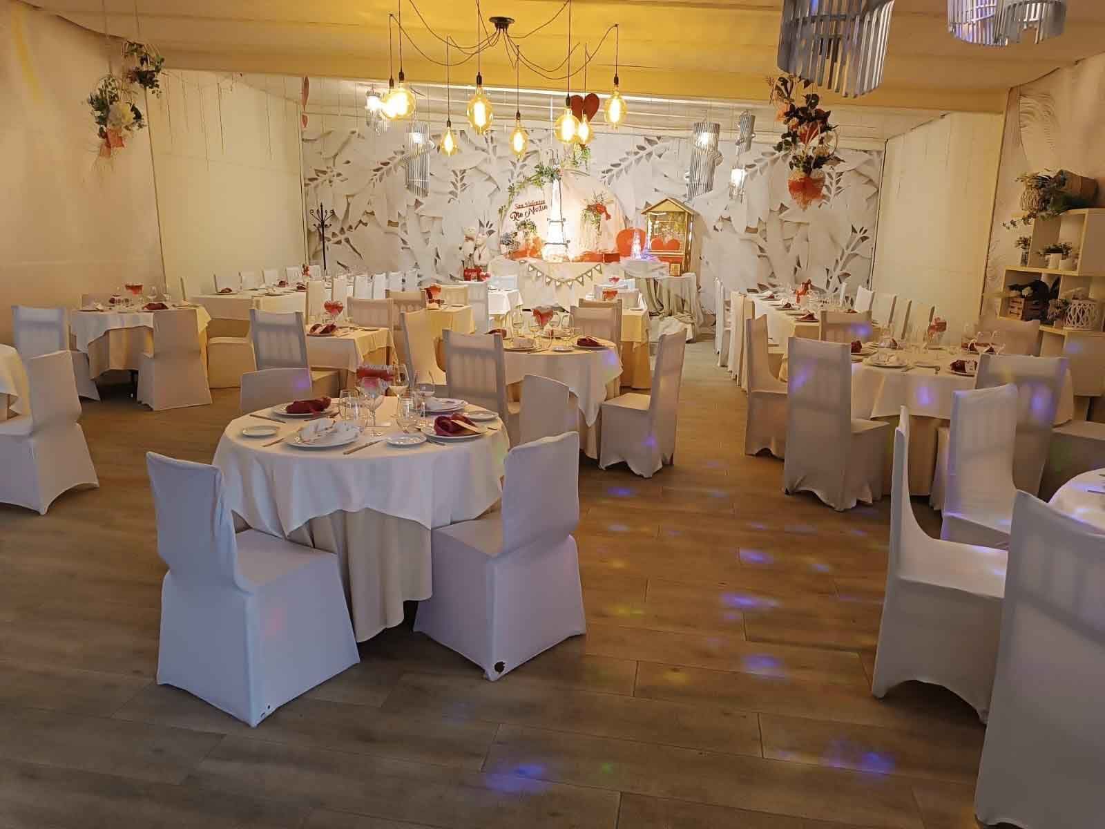 Una gran sala llena de mesas y sillas preparadas para una recepción de boda.
