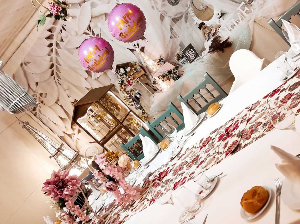 Una mesa con globos que dicen feliz cumpleaños.