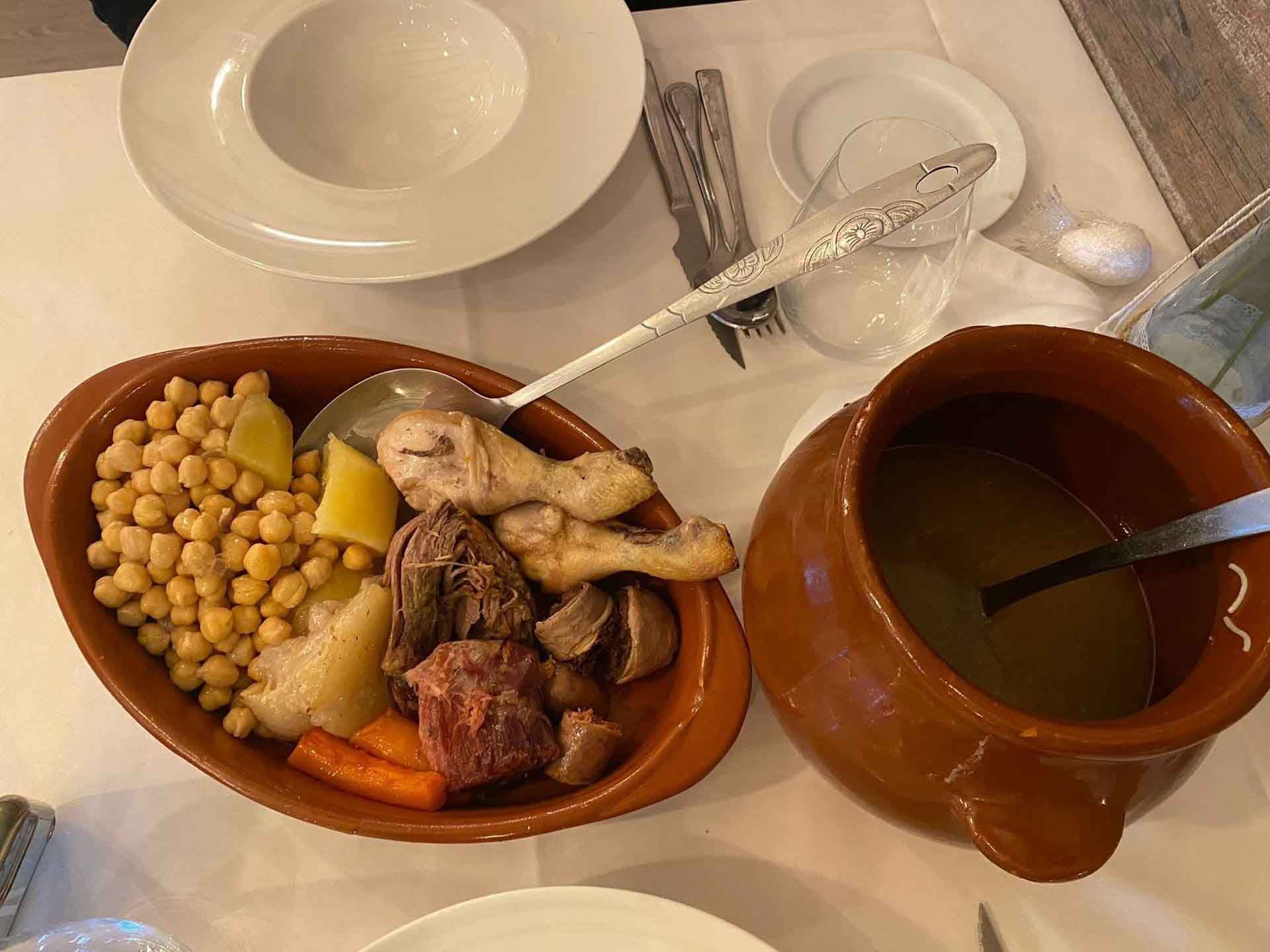 Un plato de comida y una olla de sopa sobre una mesa.