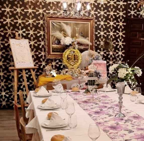 Una mesa larga con platos y vasos encima.